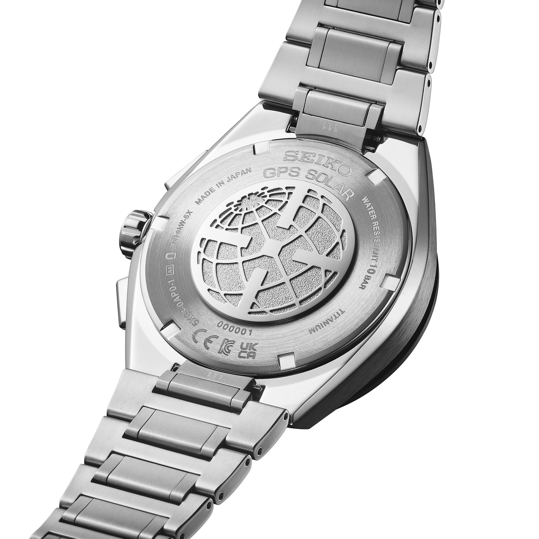 Ein silbernes Armband einer Uhr mit einem detailreichen Globus-Muster auf der Rückseite des Gehäuses.