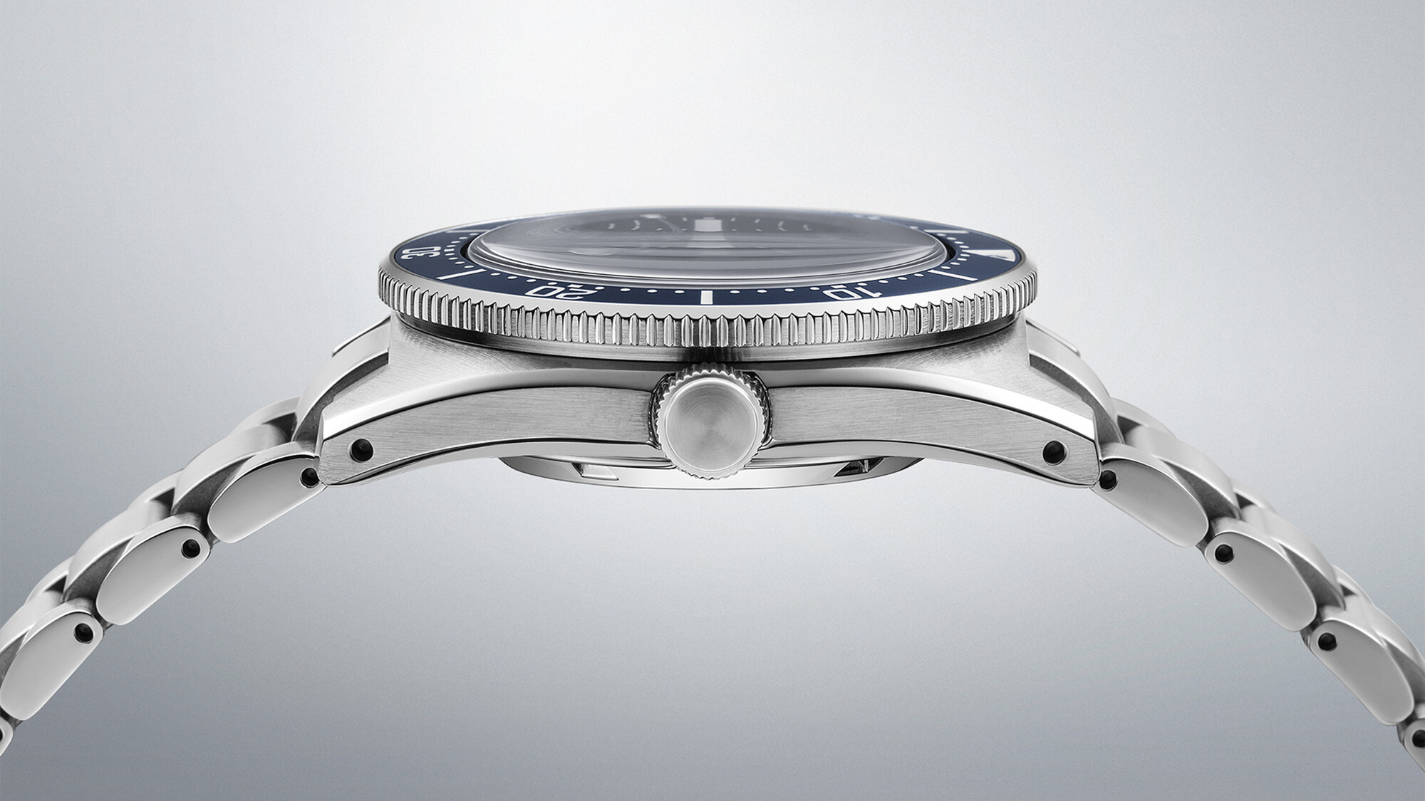 Eine silberne Armbanduhr mit einem dunkelblauen Zifferblatt, Nahaufnahme des Gehäuses und des Armbands.