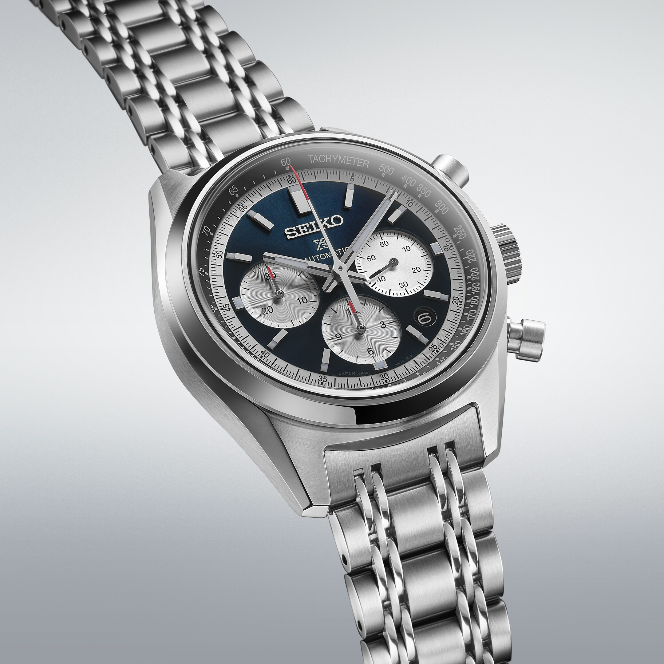 Eine silberne Herrenuhr mit einem dunkelblauen Zifferblatt und drei Chronographenanzeigen.