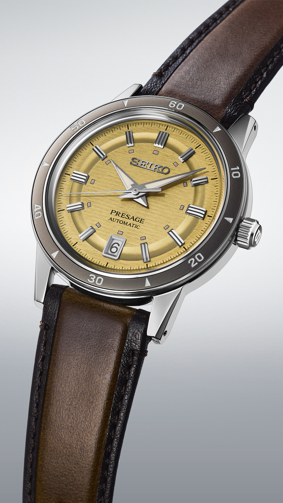 Ein klassisches Herrenarmbanduhr mit goldenem Zifferblatt und braunem Lederarmband.