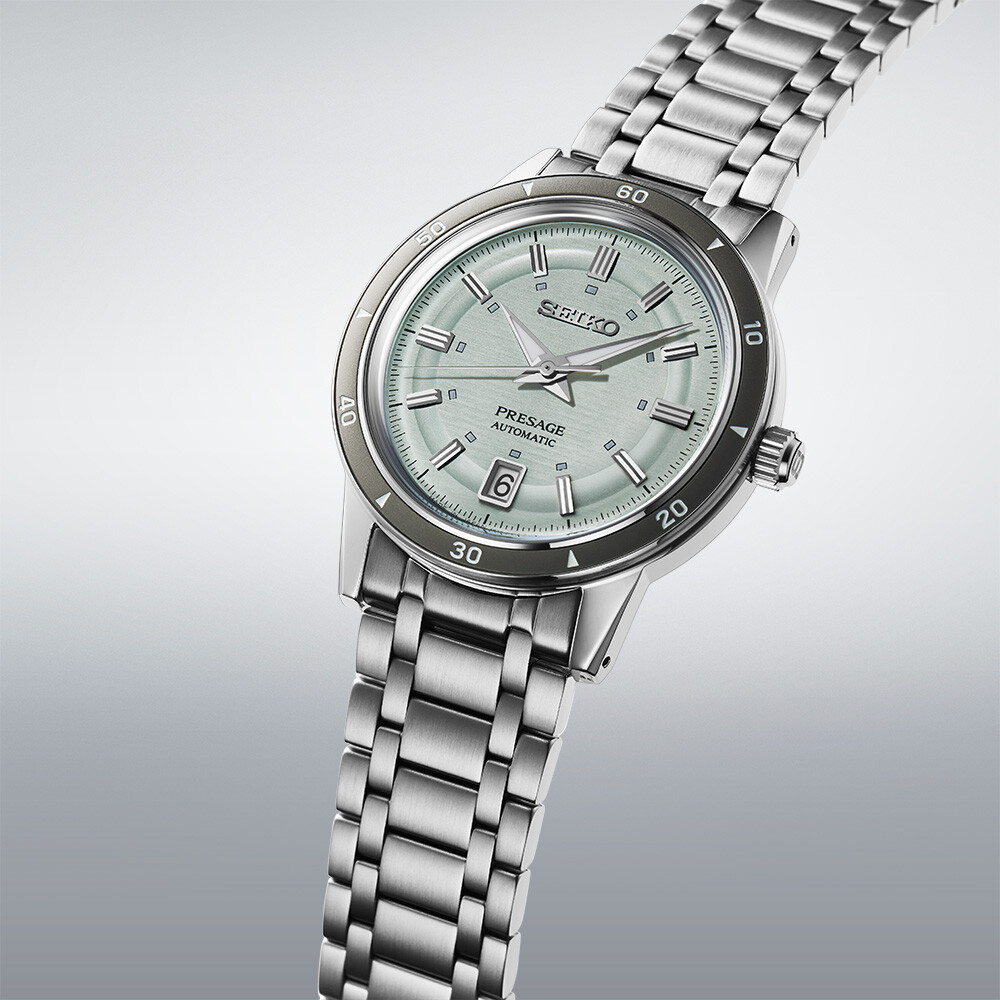 Eine silberne Automatikuhr mit hellgrünem Zifferblatt und silbernem Armband.