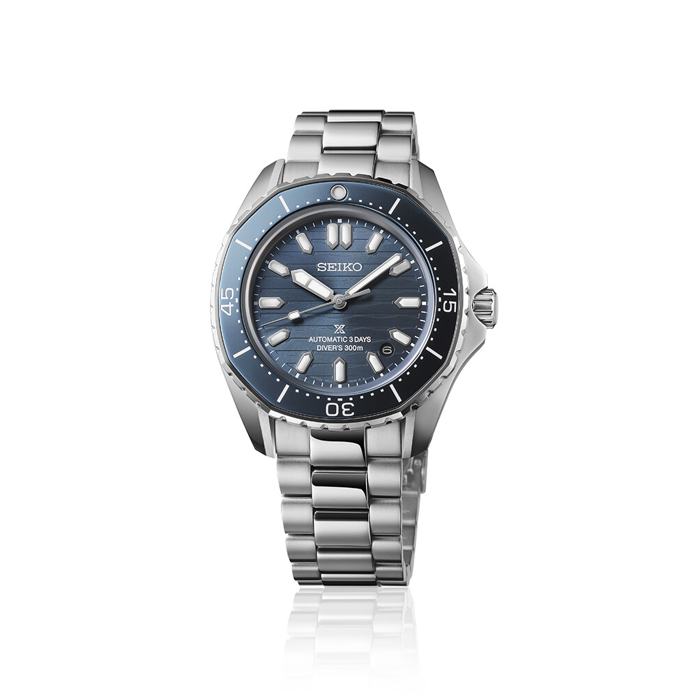 Eine Herrenuhr mit einem dunkelblauen Zifferblatt mit vertikalen Streifen und einem silbernen Armband.