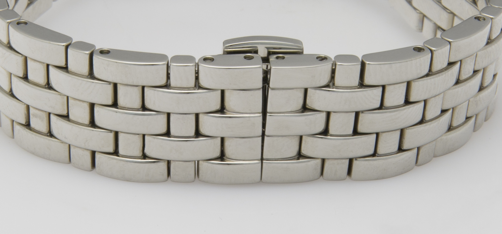 Ein silbernes Gliederarmband mit gebürsteter Oberfläche und einer breiten Schließe im Detail.