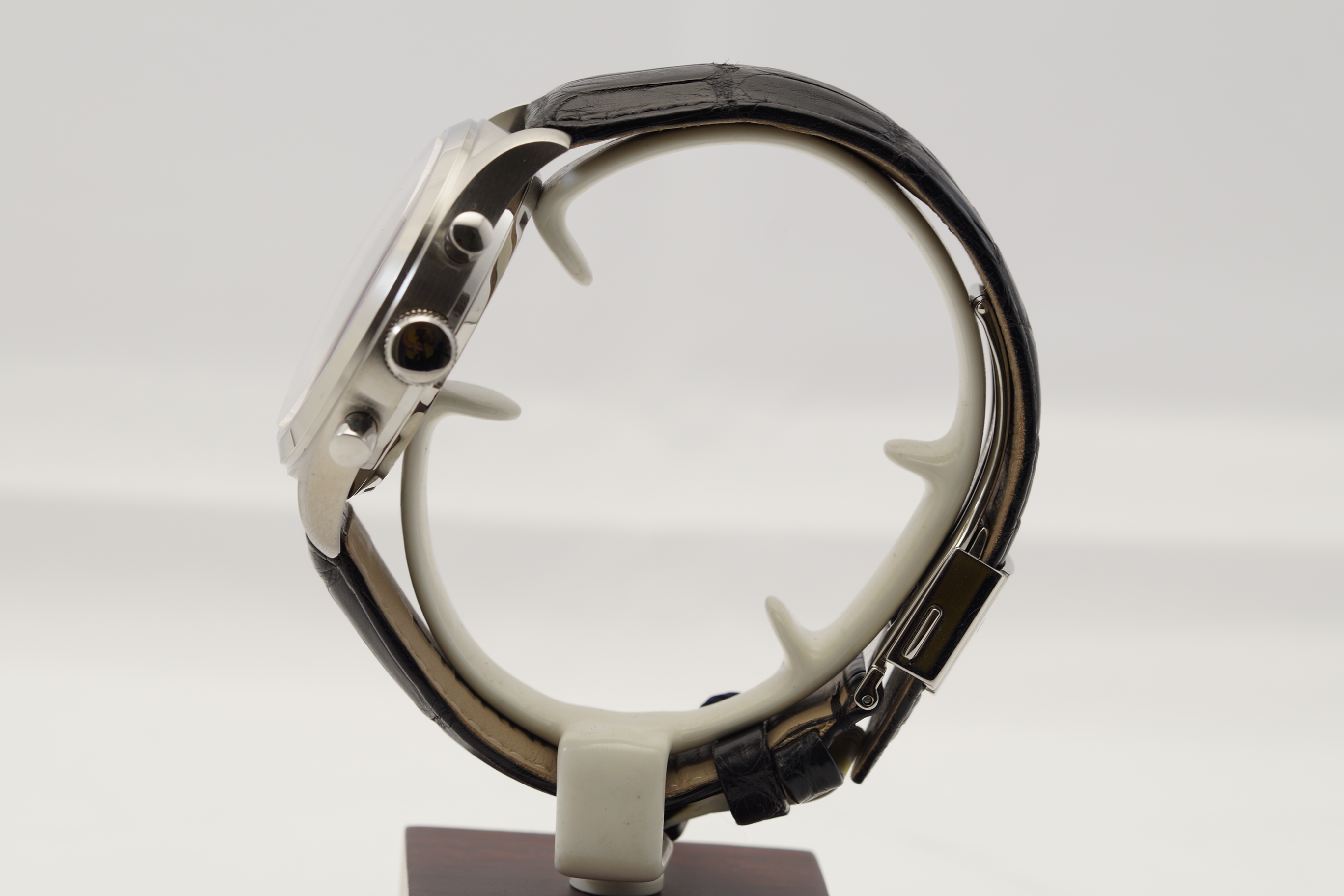 Eine Armbanduhr mit silbernem Gehäuse und schwarzem Kroko-Muster-Armband.