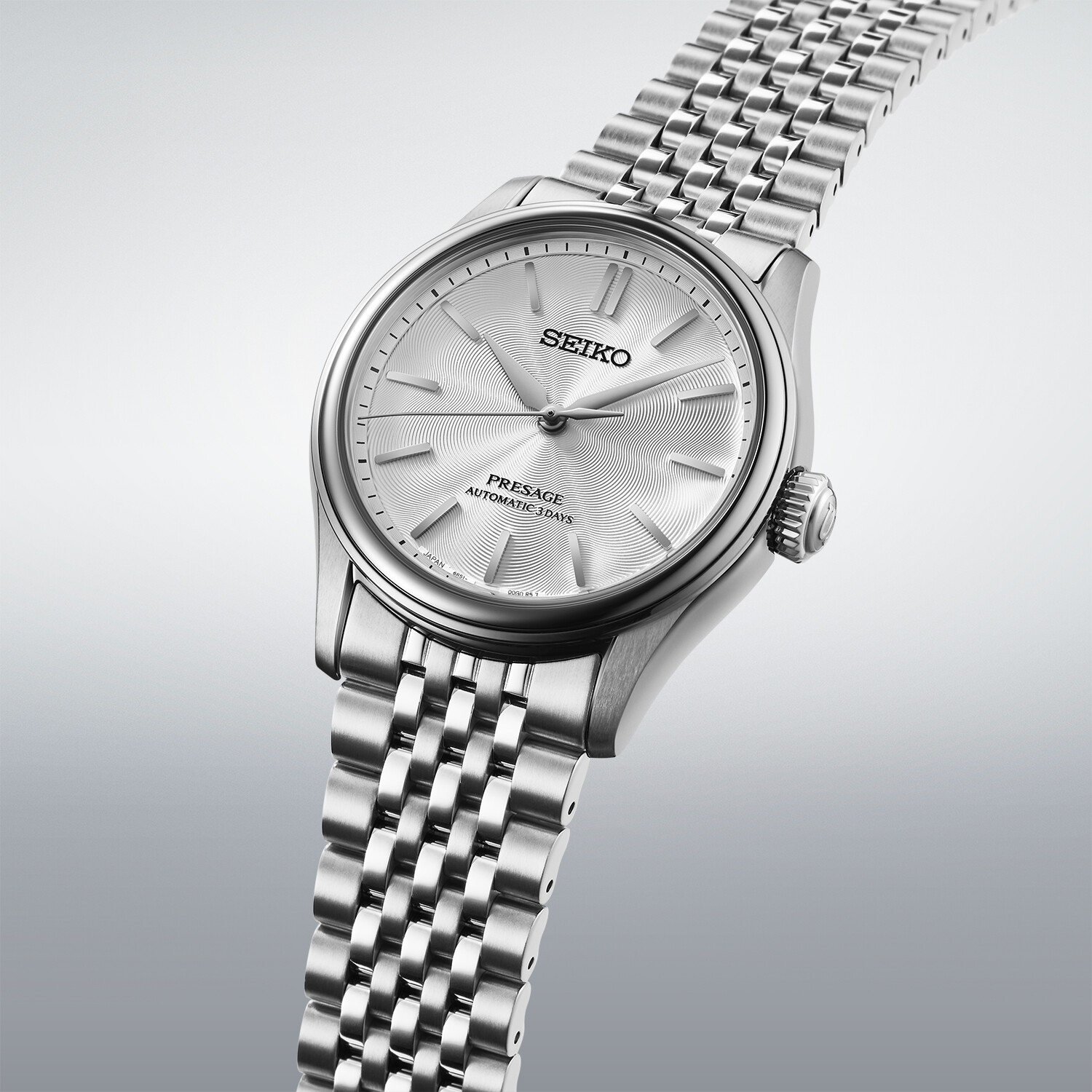 Silbernes Armbanduhr-Zifferblatt mit einem feinen Wellenmuster in Silber.