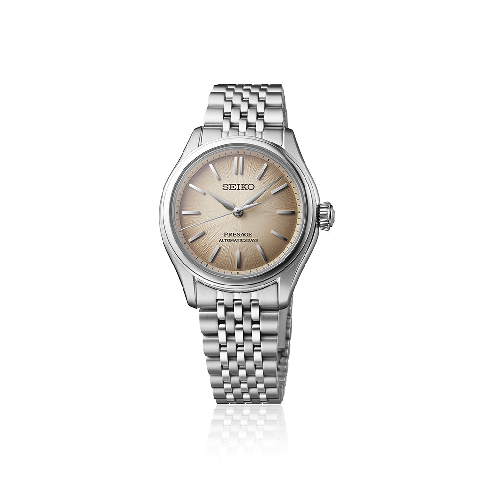 Eine elegante silberne Damenuhr mit einem beigefarbenen Zifferblatt mit radialen Strahlen und einem schmalen Metallarmband.