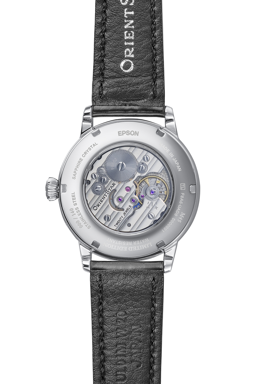 Rückseite einer silbernen Armbanduhr mit schwarzem Lederarmband und sichtbarem Uhrwerk mit blauen Akzenten.