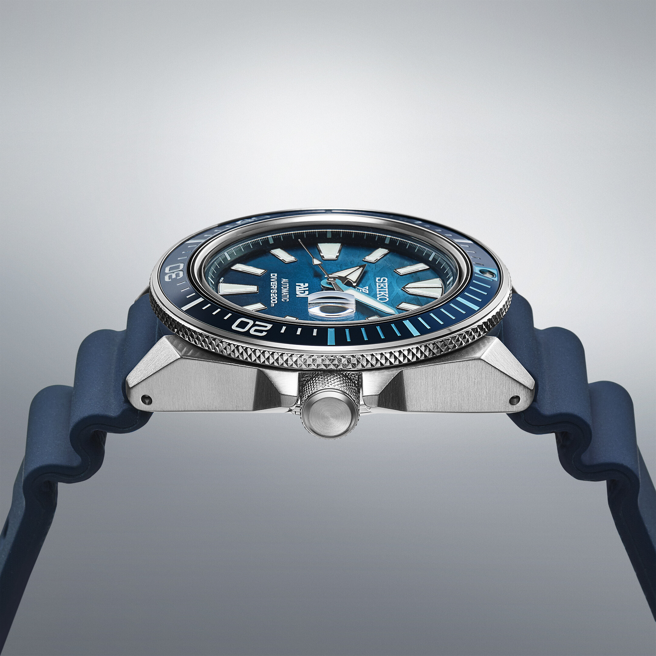 Ein Taucheruhr mit blauem Zifferblatt, silbernem Gehäuse und dunkelblauem Armband, mit detaillierter Lünette und Ziffern.