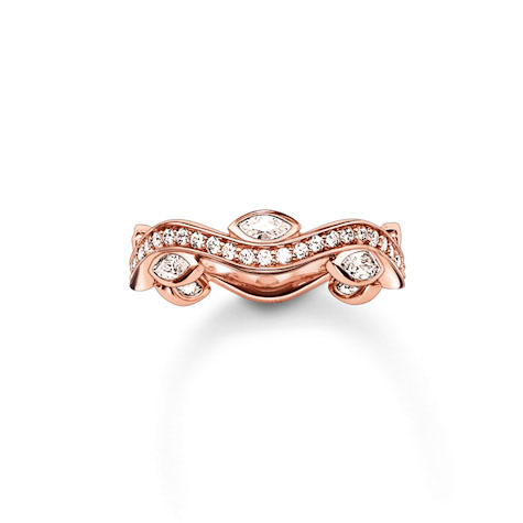 Ein roségoldfarbener Ring mit einer geschwungenen Form, besetzt mit kleinen, glitzernden Steinen und größeren, mandelförmigen Steinen.