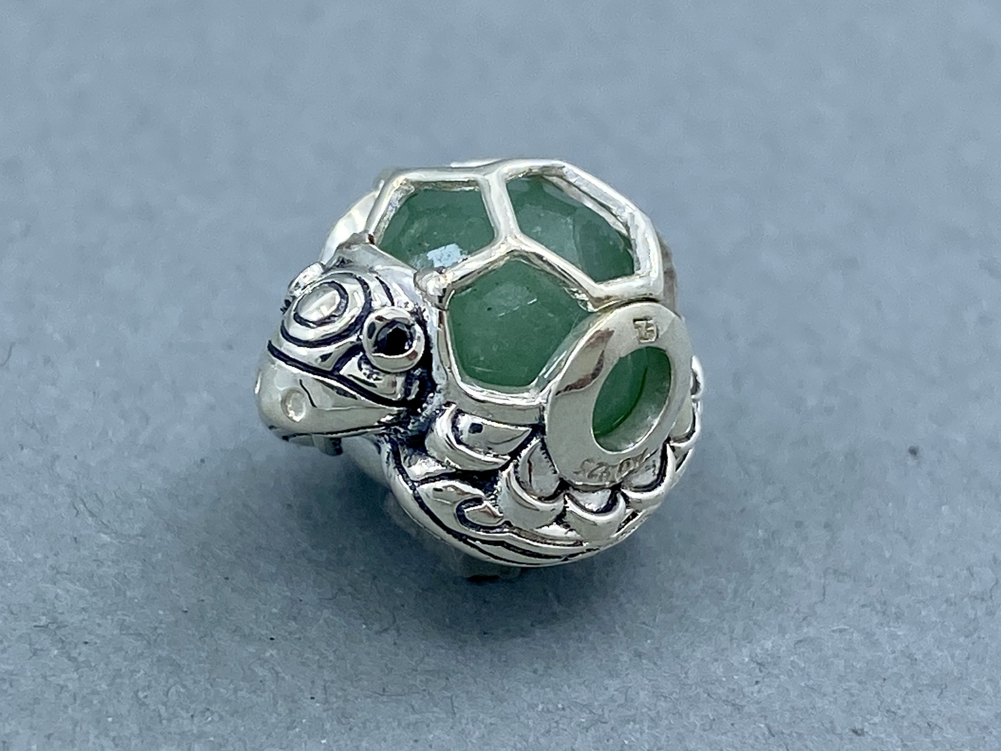 Thomas Sabo KARMA BEAD Schildkröte Anhänger mit grünem Stein und silberfarbenem Schildkrötenkörper.