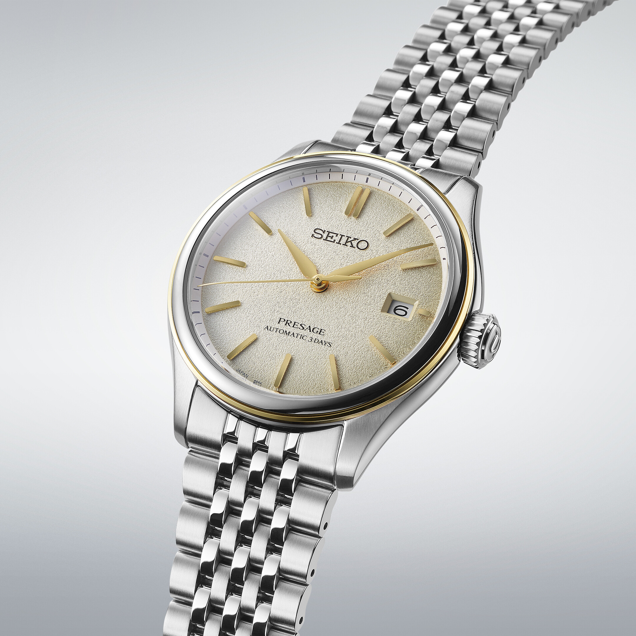 Elegante Armbanduhr mit champagnerfarbenem Zifferblatt mit guillochiertem Muster und goldfarbenen Zeigern und Indizes.
