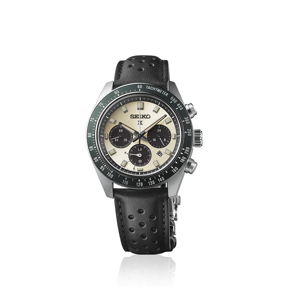 Eine silberne Herrenuhr mit hellem Zifferblatt, zwei schwarzen Hilfszifferblättern und einem grünen Tachymeter-Ring, getragen an einem schwarzen Lederarmband.