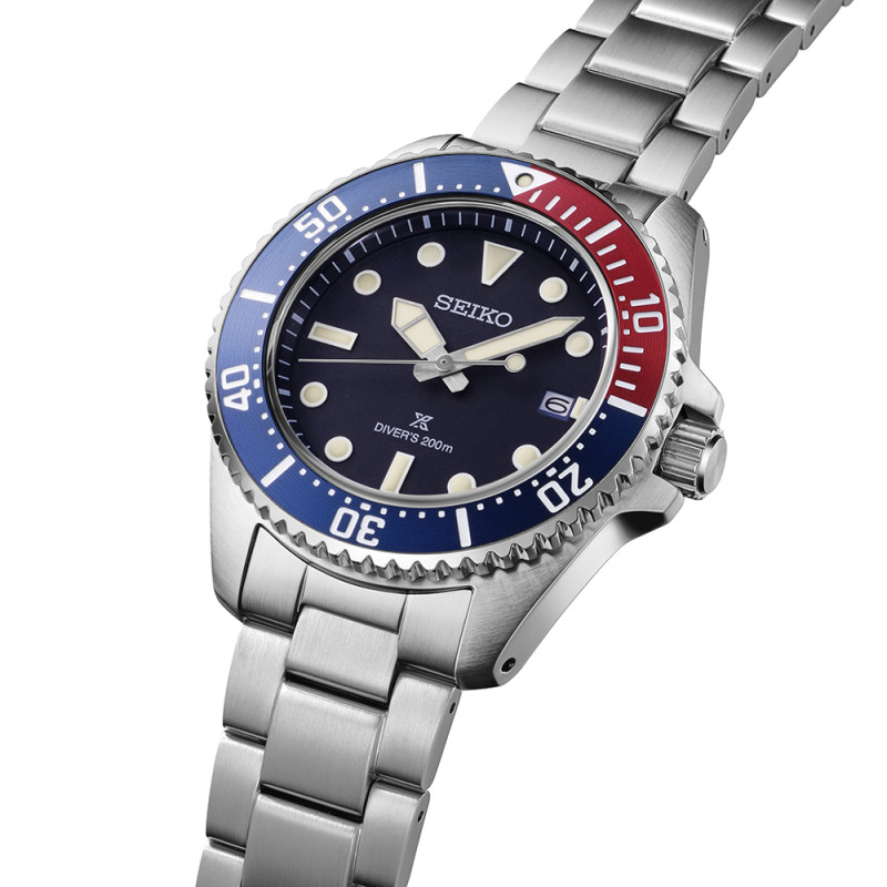 Herrenuhr mit dunkelblauem Zifferblatt und rot-blauer Lünette auf einem Metallarmband