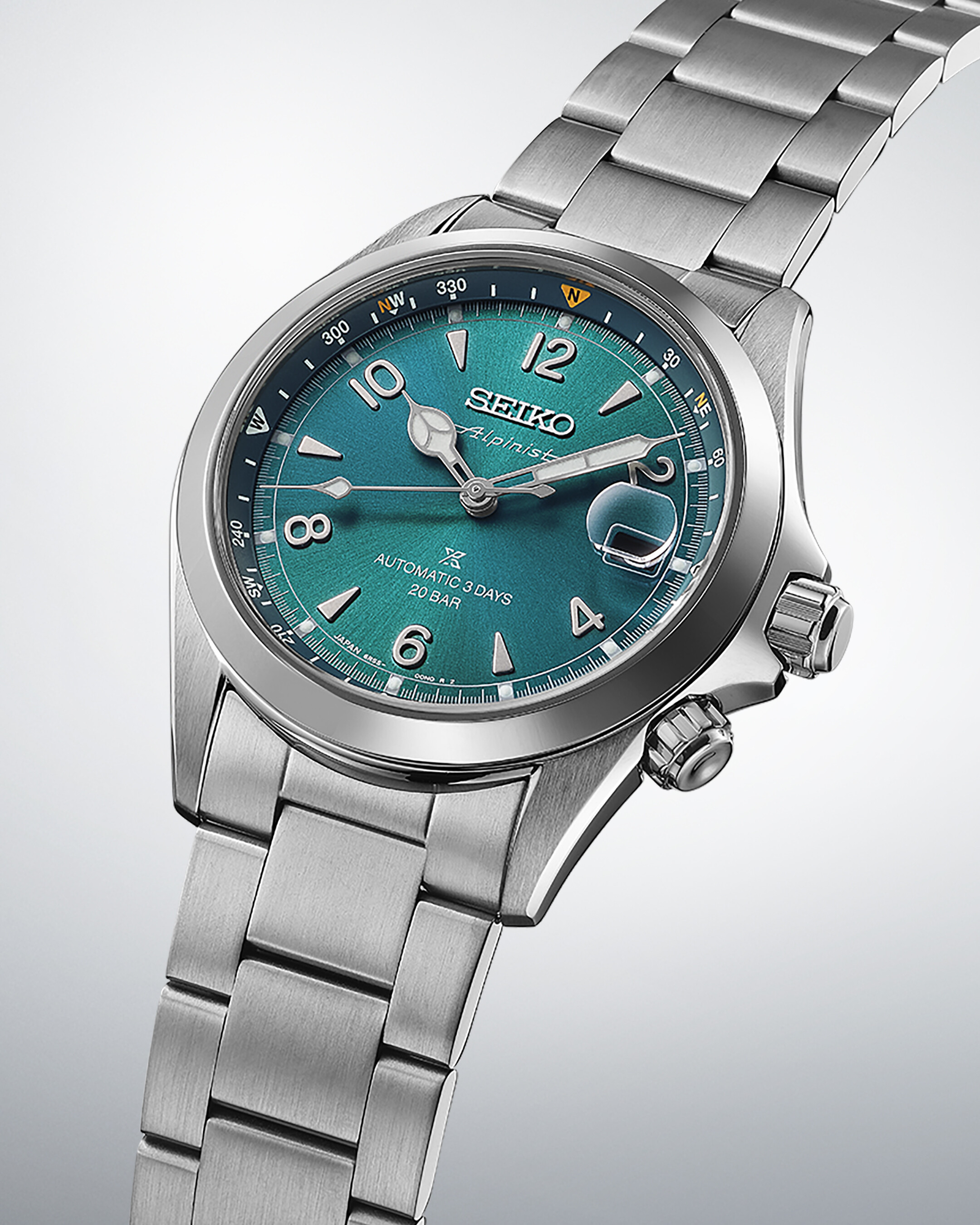 Eine silberne Armbanduhr mit einem tiefgrünen, blau schimmernden Zifferblatt. Indizes und Zeiger sind silberfarben.