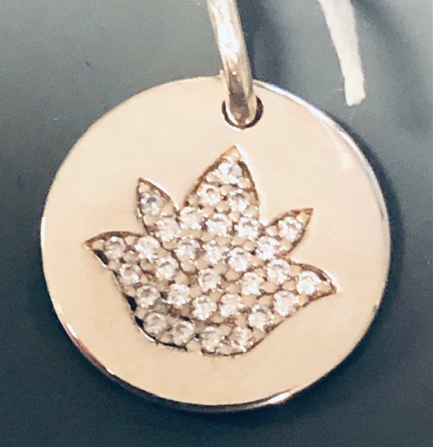 Eine runde, goldene Münze mit einem detaillierten Vogelmotiv, besetzt mit vielen kleinen, glitzernden Steinen.