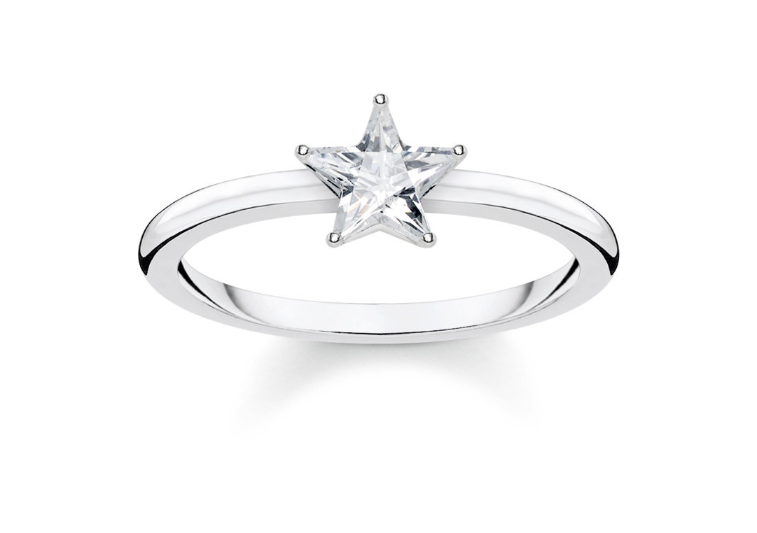 Ein silberner Ring mit einem weißen, sternförmigen Stein als auffälligem Mittelpunkt.