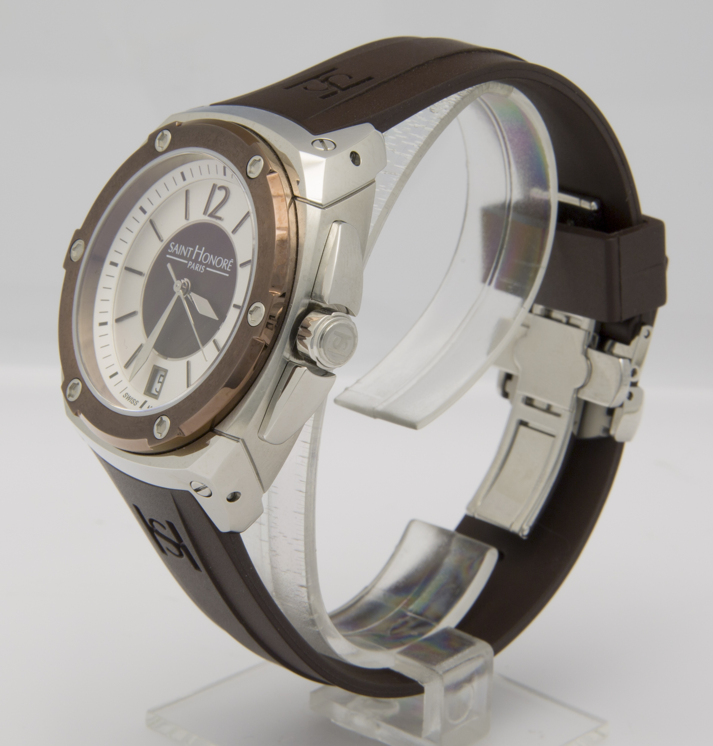 Eine silberne und bronzene Uhr mit einem dunkelbraunen Armband, die auf einem transparenten Ständer sitzt.