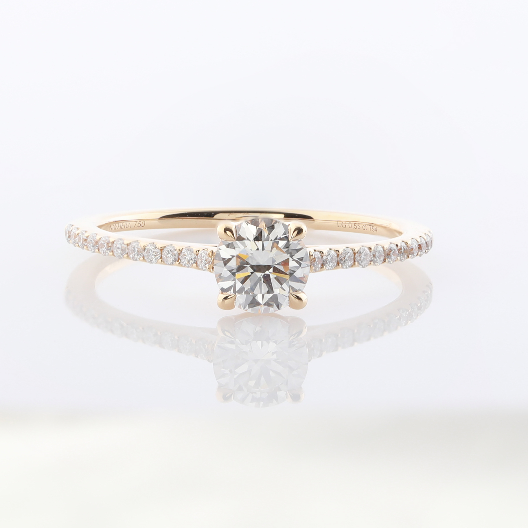 Ein goldener Verlobungsring mit einem runden Diamanten und kleineren Diamanten auf dem Ringband.