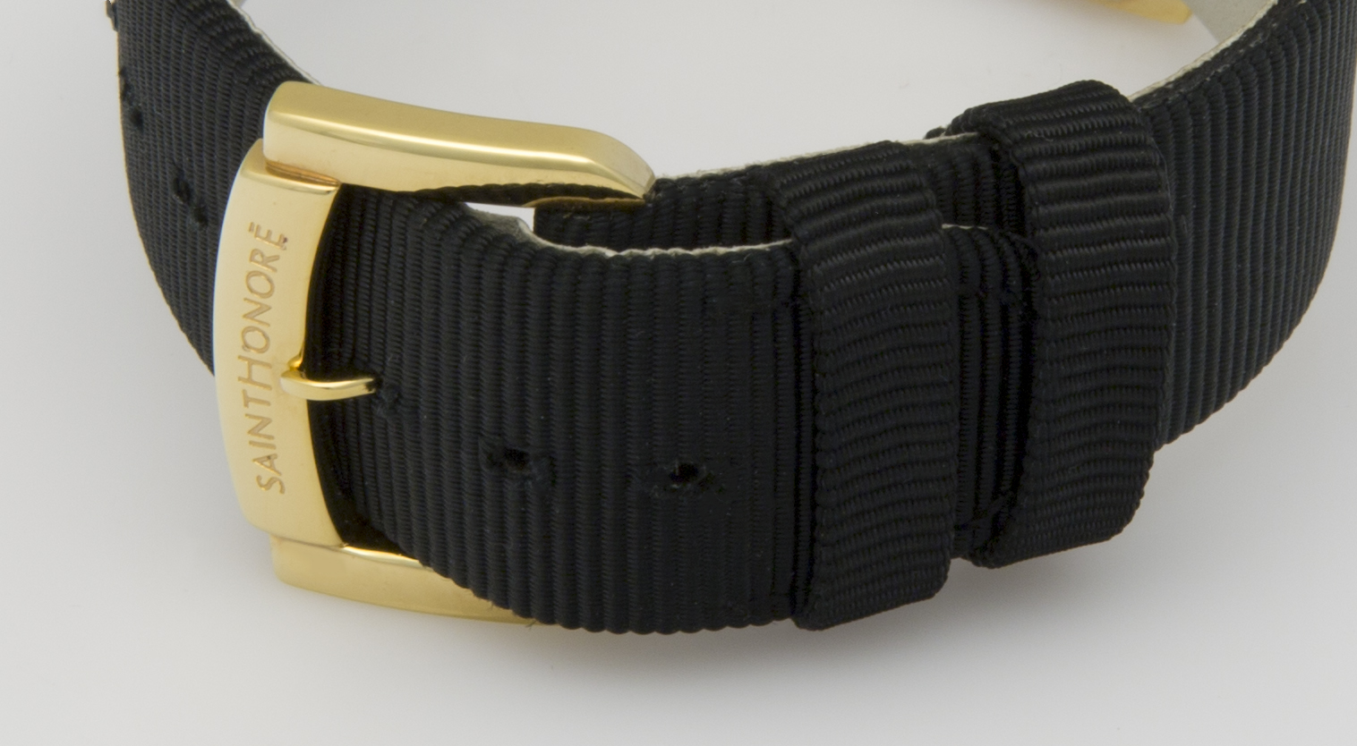 Schwarzes Armband mit Goldschnalle, mit sichtbaren Nähten und Gürtelschlaufe.
