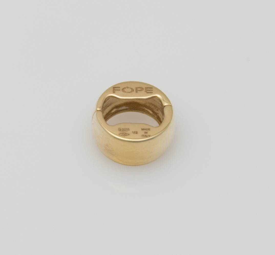 Ein goldener Ring mit der Prägung "FOPE" ist auf einem hellgrauen Hintergrund abgebildet.