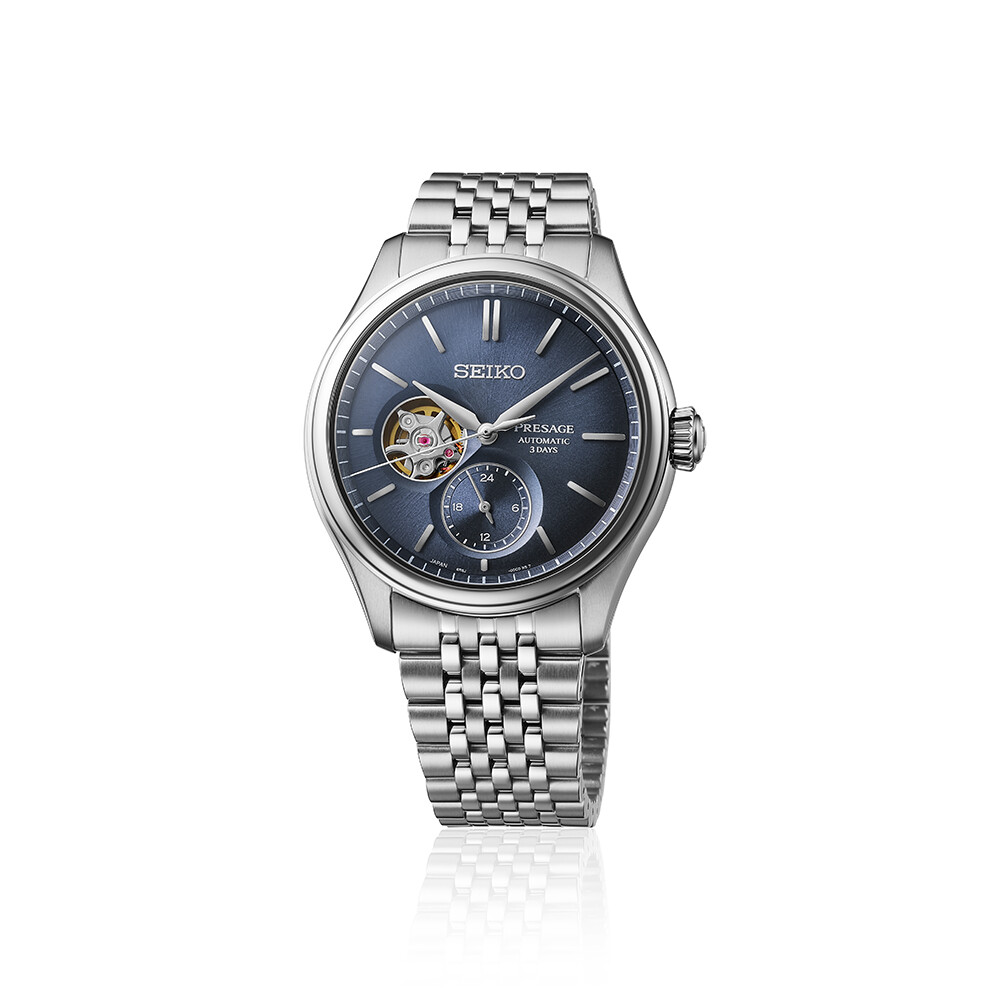 Seiko Presage Automatik mit einem tiefblauen Zifferblatt und einem Fenster, das das Uhrwerk zeigt, an einem silberfarbenen Armband.