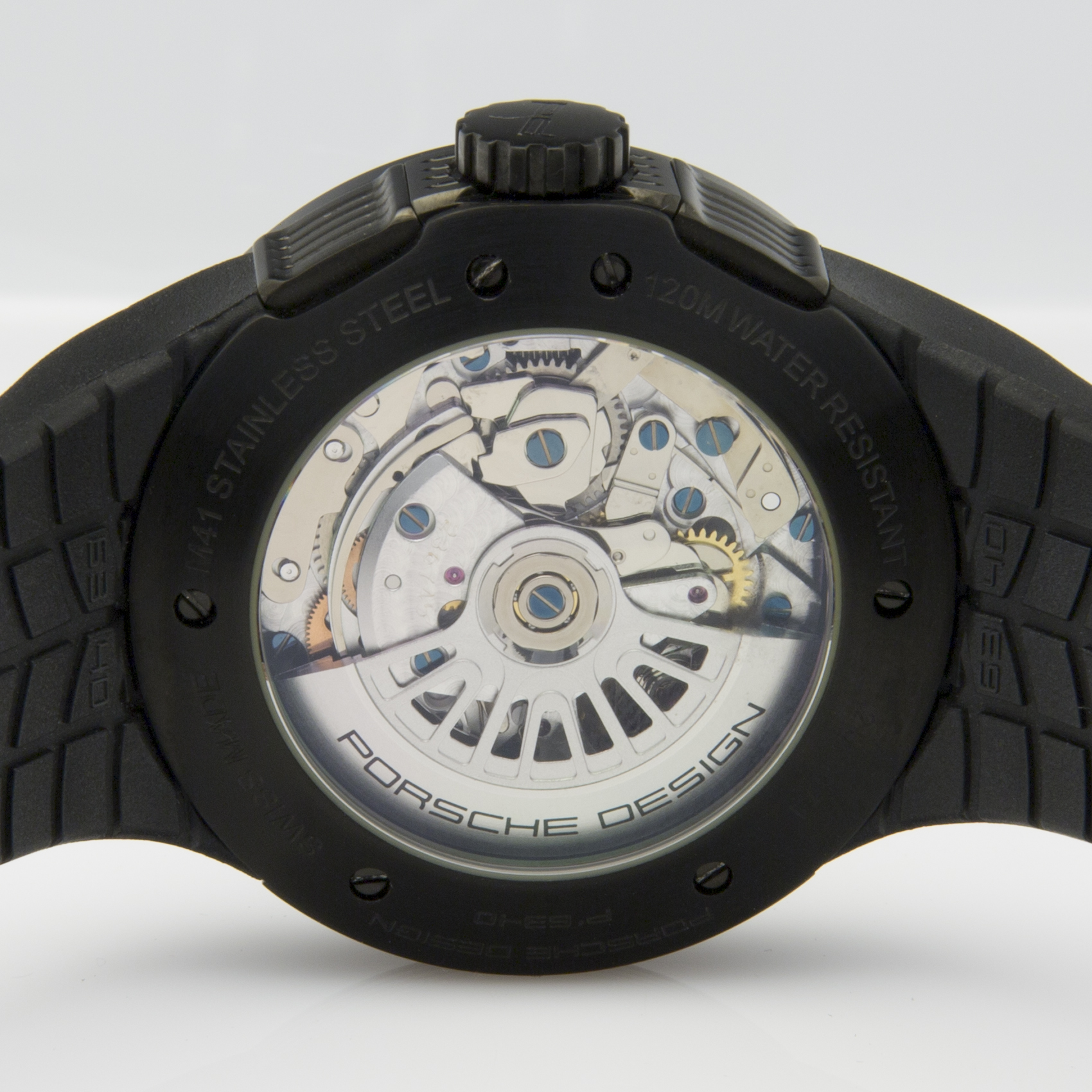 Ein schwarzes Armbanduhr-Gehäuse mit offenem Sichtboden, der das silberne Uhrwerk mit blauen Schrauben und Zahnrädern zeigt.