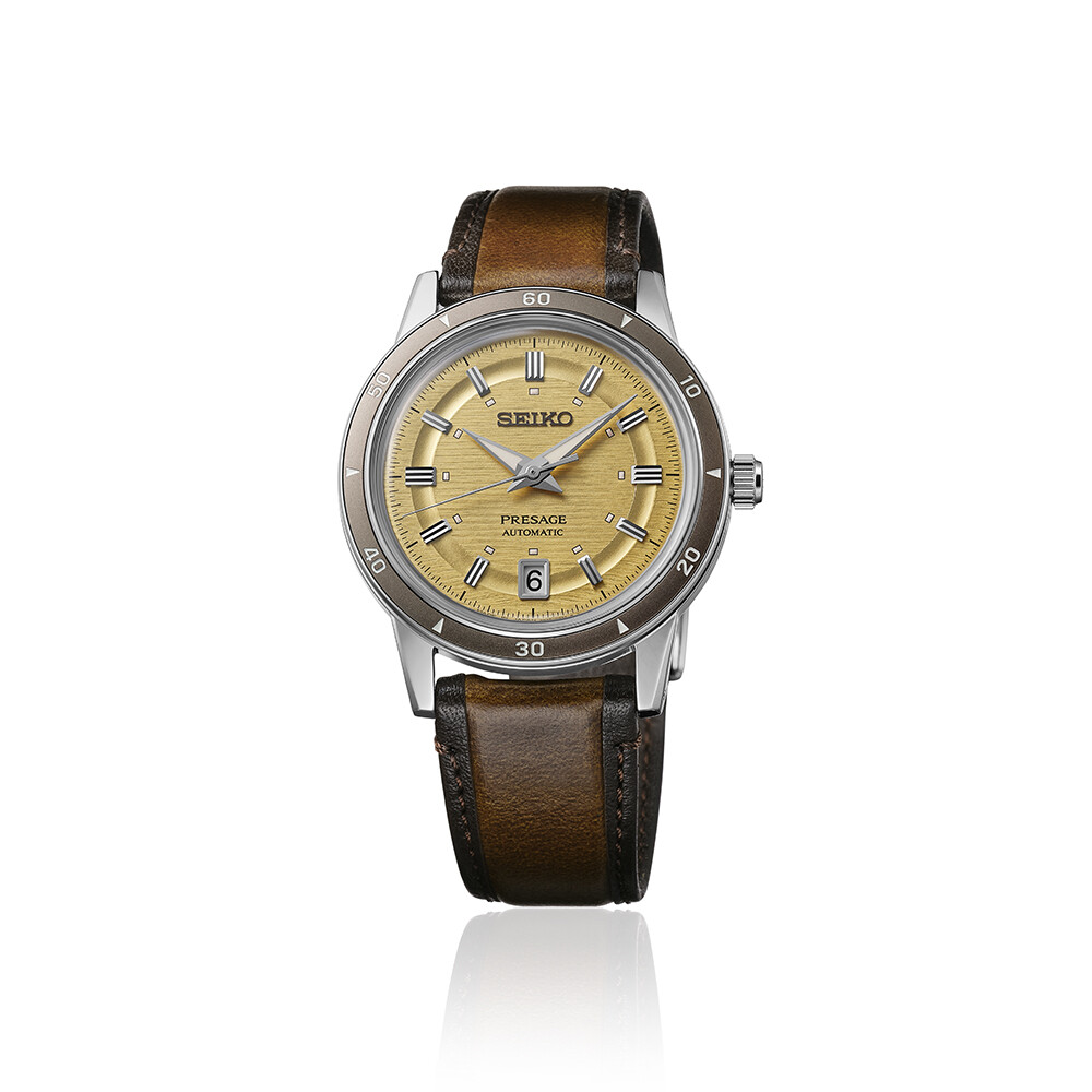 Eine goldene Uhr mit braunem Armband. Das Zifferblatt ist goldfarben mit radialen Linien.