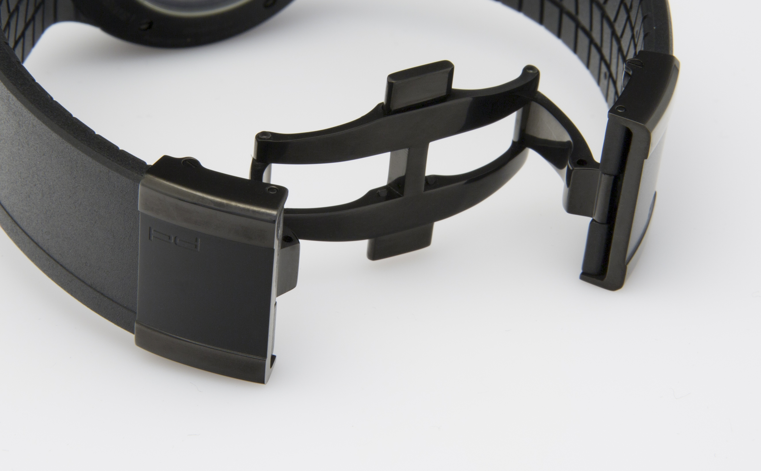Ein schwarzes Uhrenarmband mit einer auffälligen schwarzen Faltschließe, die ein poliertes Muster aufweist.