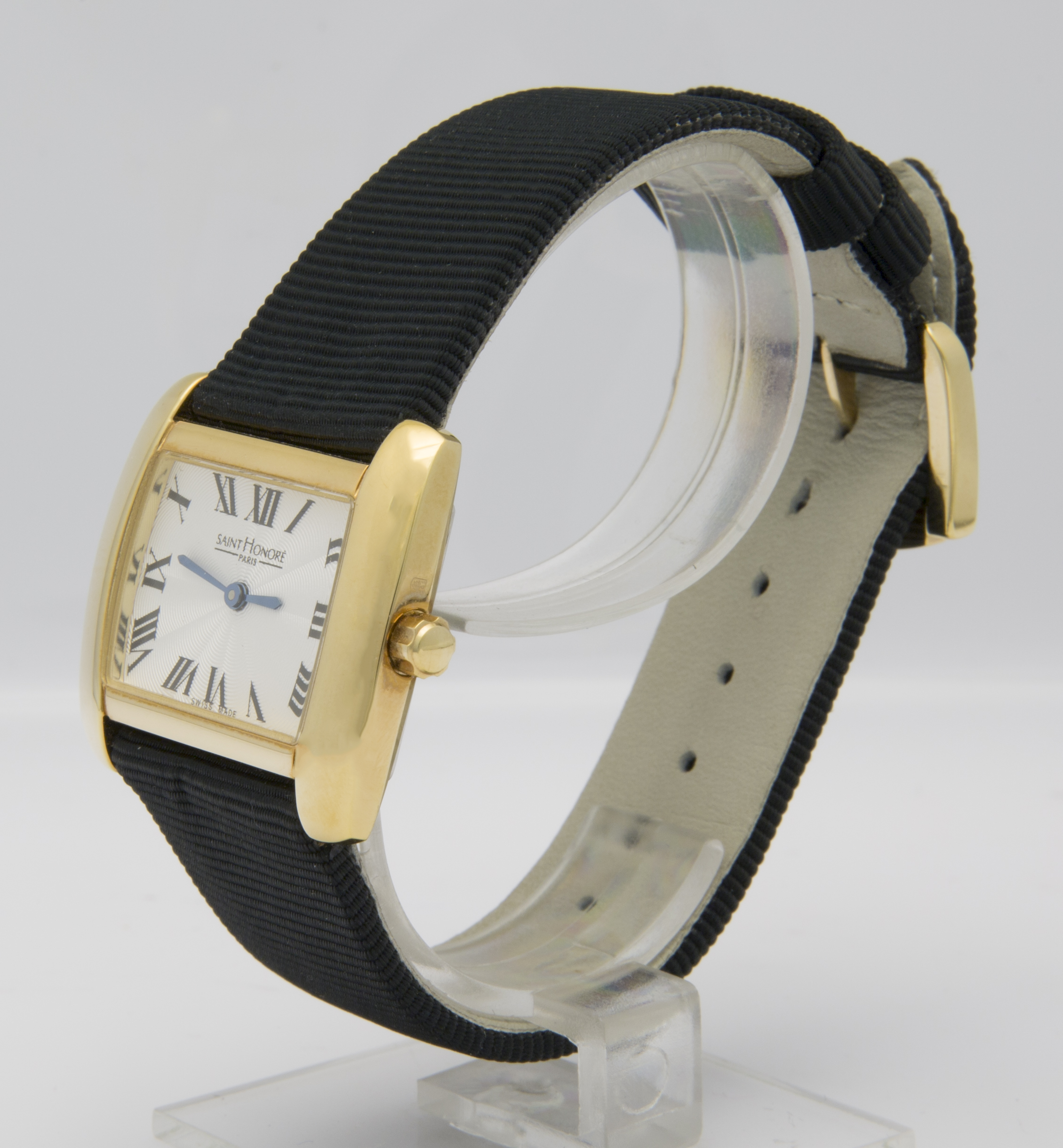 Eine goldene Damenuhr mit schwarzem Armband und weißem Zifferblatt mit römischen Ziffern.