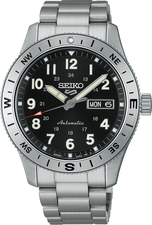 Die Seiko 5 Sports Uhr verfügt über ein robustes silberfarbenes Gehäuse und Armband sowie ein schwarzes Zifferblatt mit auffälligen Indizes und Zeigern.