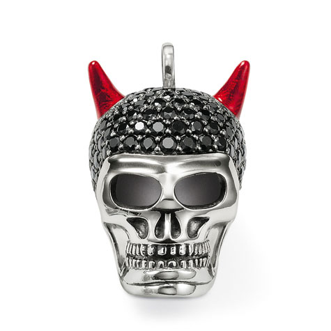 Ein silberner Anhänger in Totenkopfform mit roten Teufelshörnern und einem schwarzen, funkelnden Schädel.