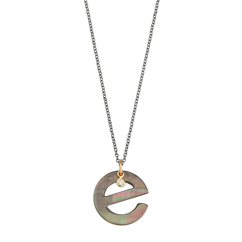 Ein zierliches Collier mit einem Anhänger in Form des Buchstabens "e", verziert mit einem kleinen, funkelnden Stein.