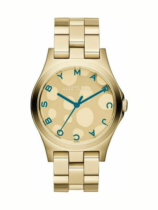 Eine goldfarbene Marc Jacobs Damenuhr mit einem hellen Zifferblatt mit runden Tupfen und blauen Zeigern.